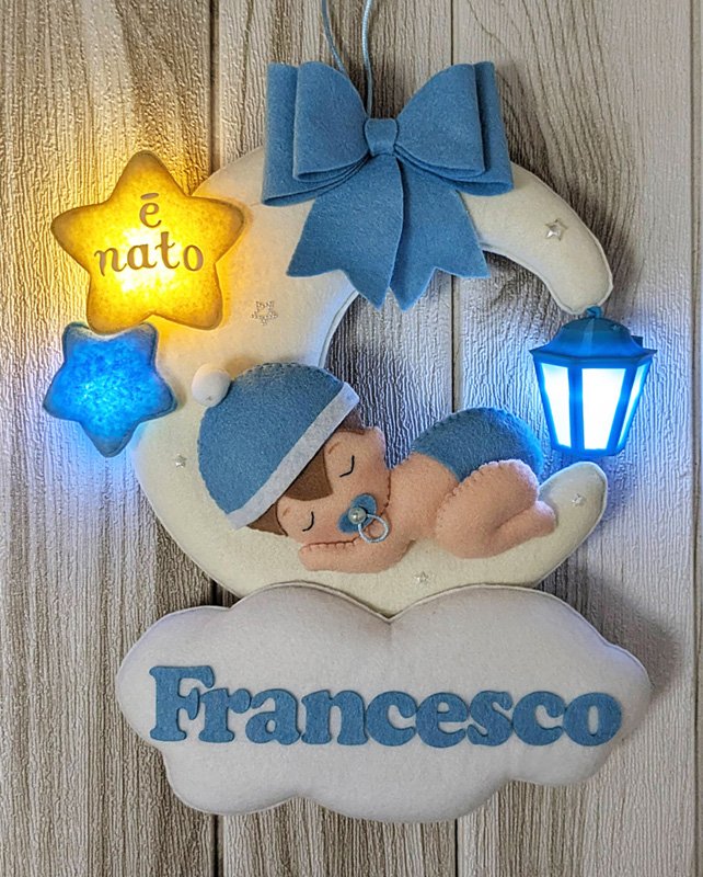Fiocco nascita fatto a mano con lanterna luminosa, bimbo che dorme sulla luna, nuvola con nome e fiocchetto e stelle decorativi